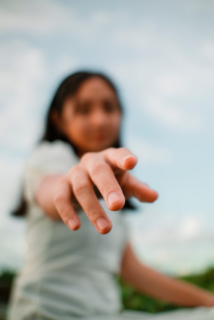 a woman in a white dress pointing at the camera